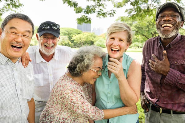 four senior men and two senior women laughing and smiling outside