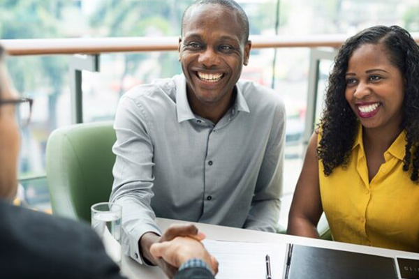 smiling couple talking to an insurance agent